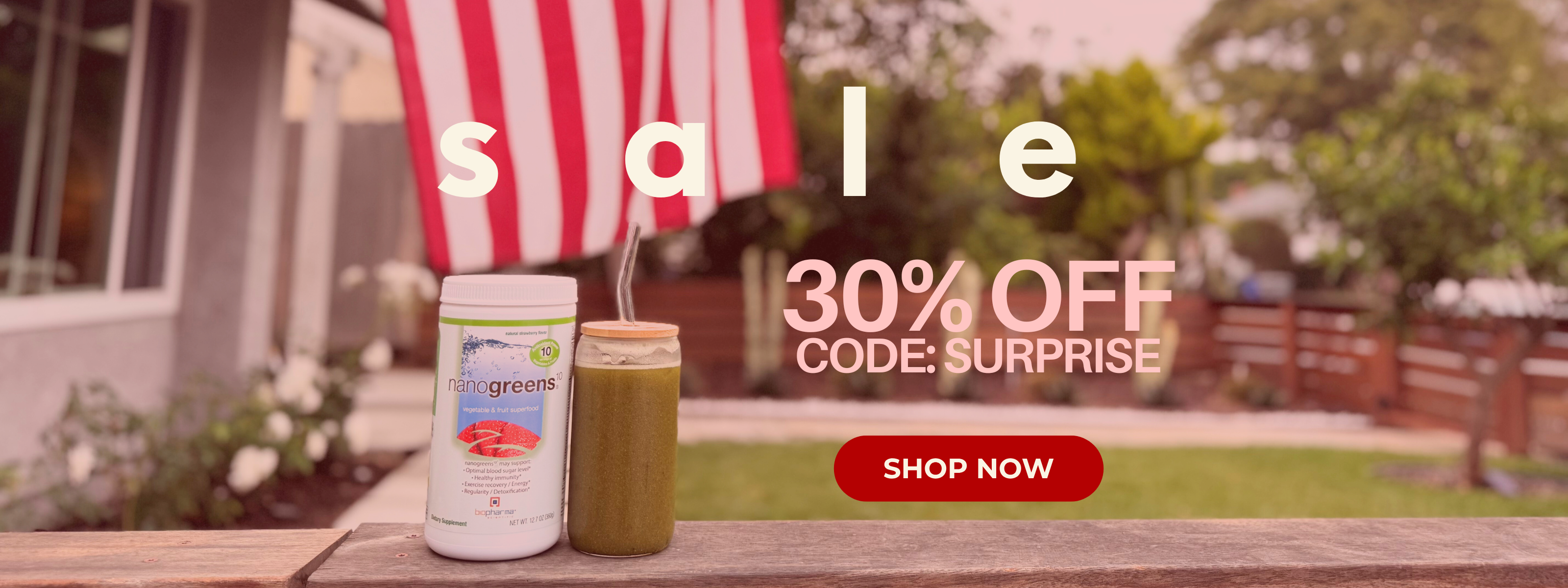 Promotional banner with a smoothie and supplement bottle on a table outdoors, featuring a sale and discount code.